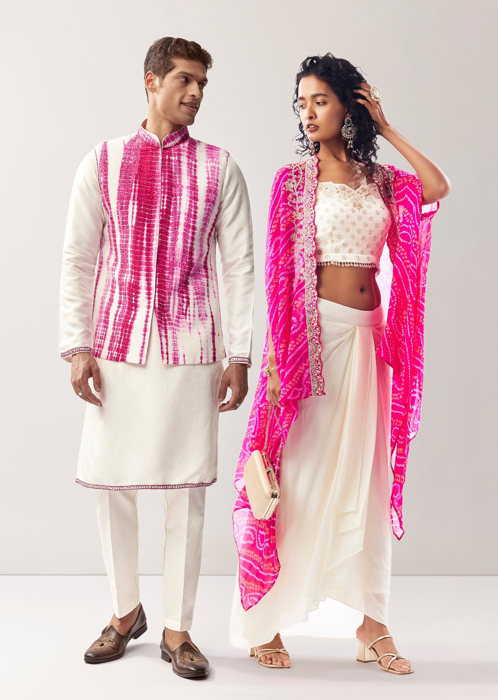 Vibrant Bandhani Festive Couple Set – Bandhani Cape Skirt Set For Her And Pink Silk Tie-Dye Kurta Jacket Set For Him